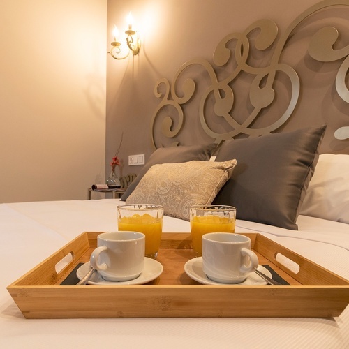 una bandeja de madera con dos tazas de café y un vaso de jugo de naranja