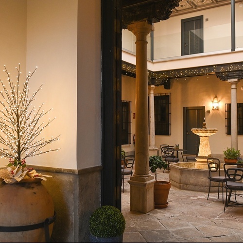 un grupo de personas están sentadas en mesas y sillas en un restaurante al aire libre