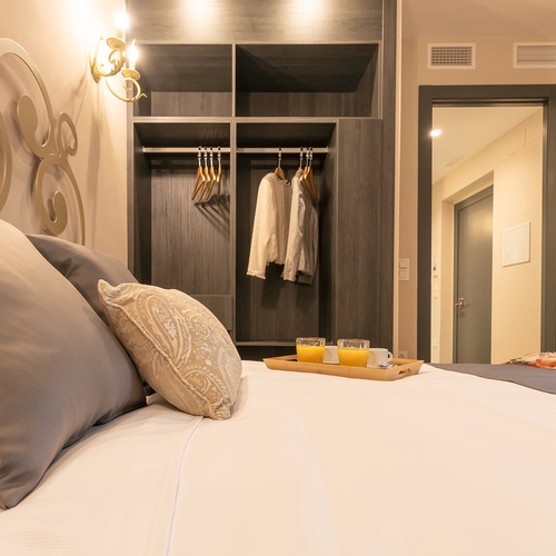 una cama con una bandeja de zumo de naranja encima