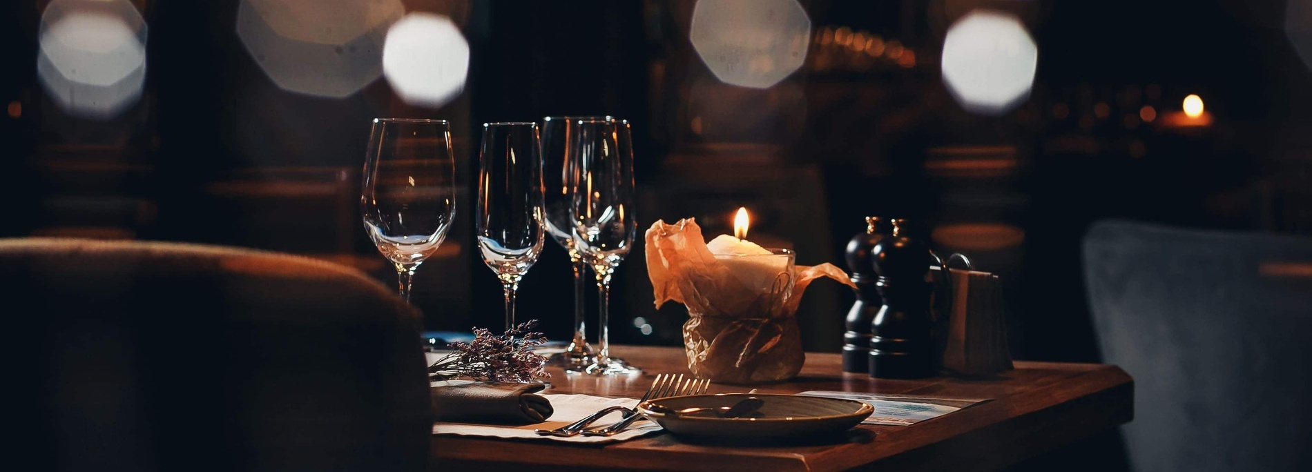 a table with two wine glasses and a candle on it