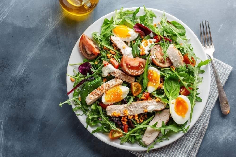 a white plate topped with a salad and a fork
