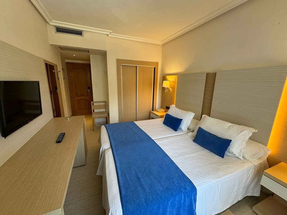 una habitación de hotel con dos camas y una pintura del océano en la pared .