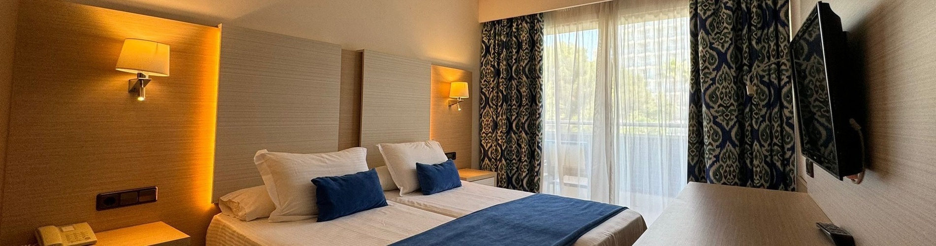 ein Hotelzimmer mit zwei Betten und einem Fernseher