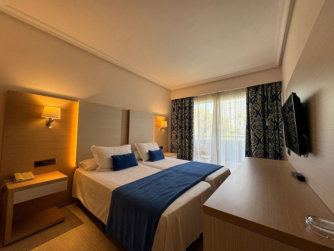 ein Hotelzimmer mit zwei Betten und einem Fernseher