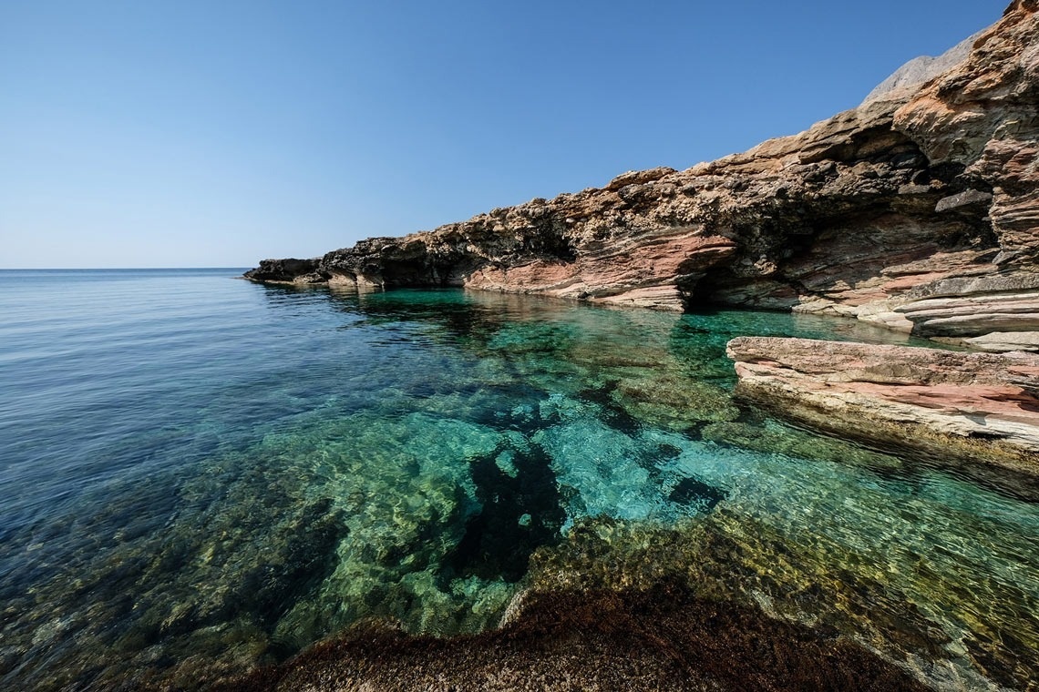 a large body of water surrounded by rocks and trees