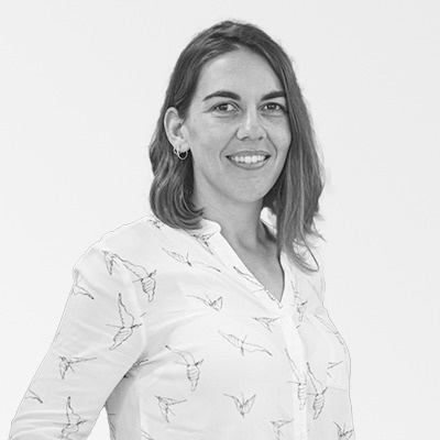 a woman in a white shirt with birds on it is smiling in a black and white photo .