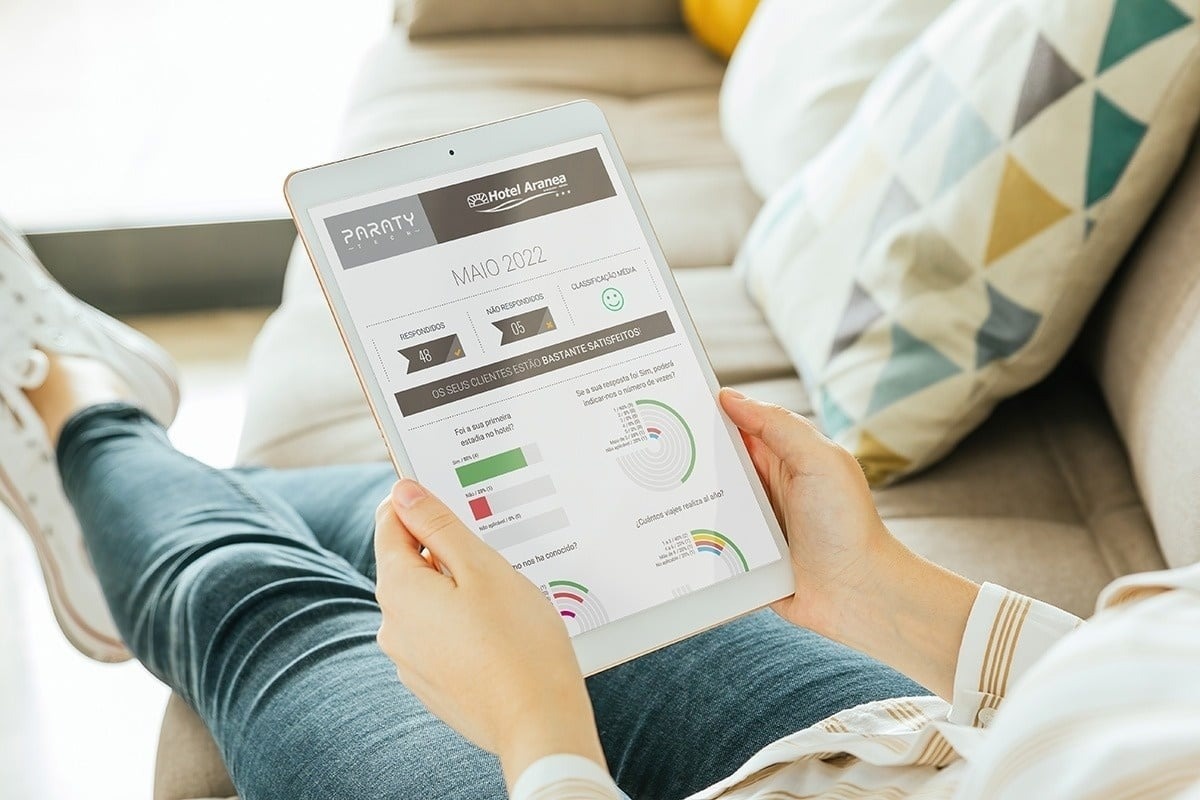 una persona sostiene una tableta con una página de hotel avenue en la pantalla