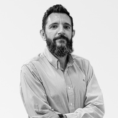 a man with a beard is standing with his arms crossed in a black and white photo .