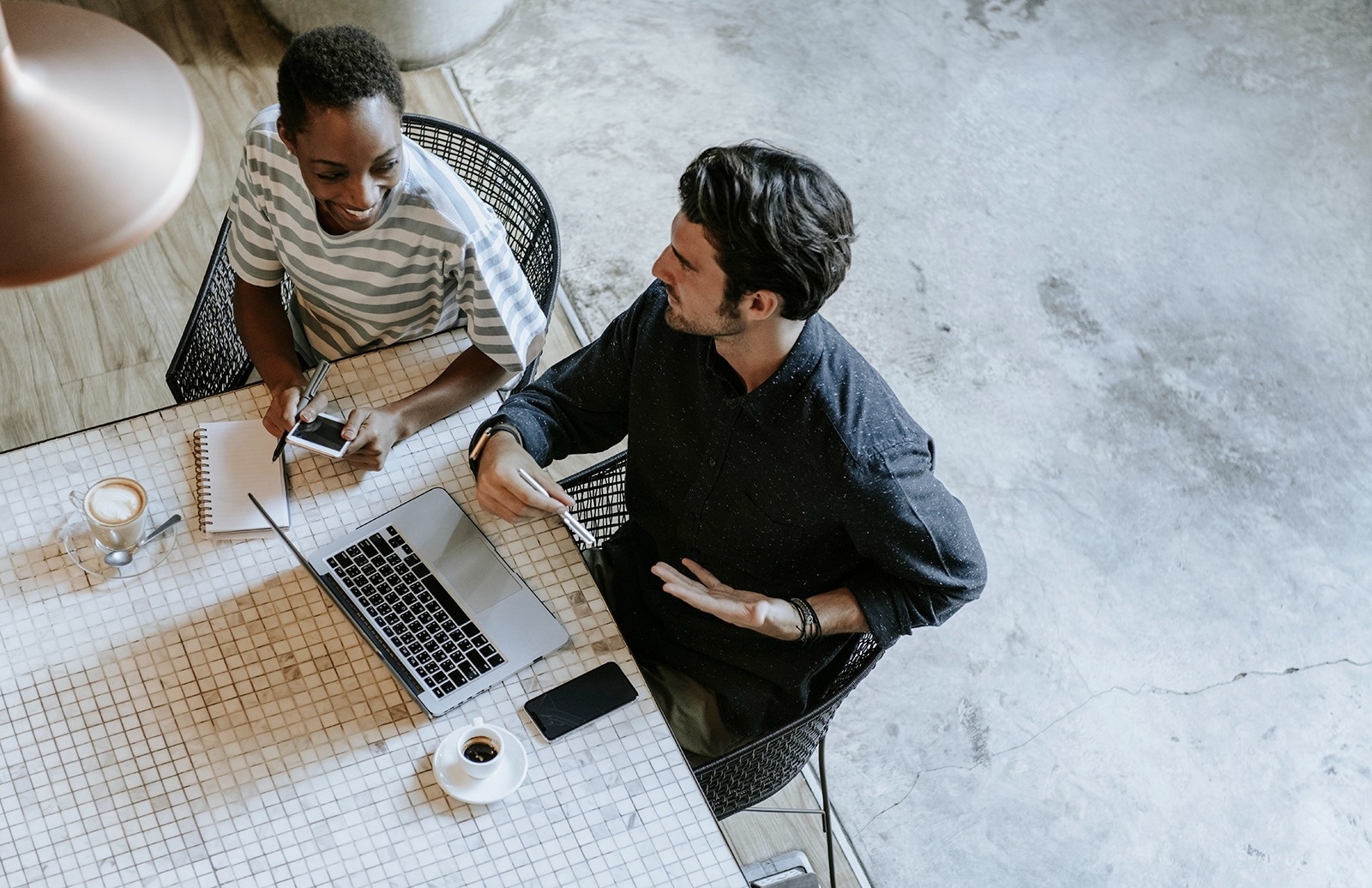 un hombre y una mujer están sentados en una mesa con una computadora portátil