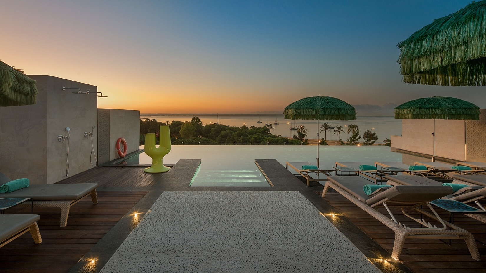 a large swimming pool surrounded by palm trees and chairs
