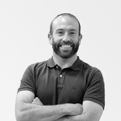 a man with a beard wearing a black polo shirt with a skull on it