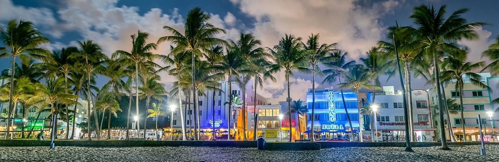 a large swimming pool surrounded by palm trees and chairs