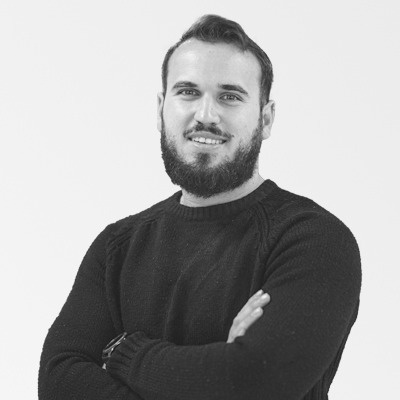 a man with a beard is wearing a black sweater with his arms crossed