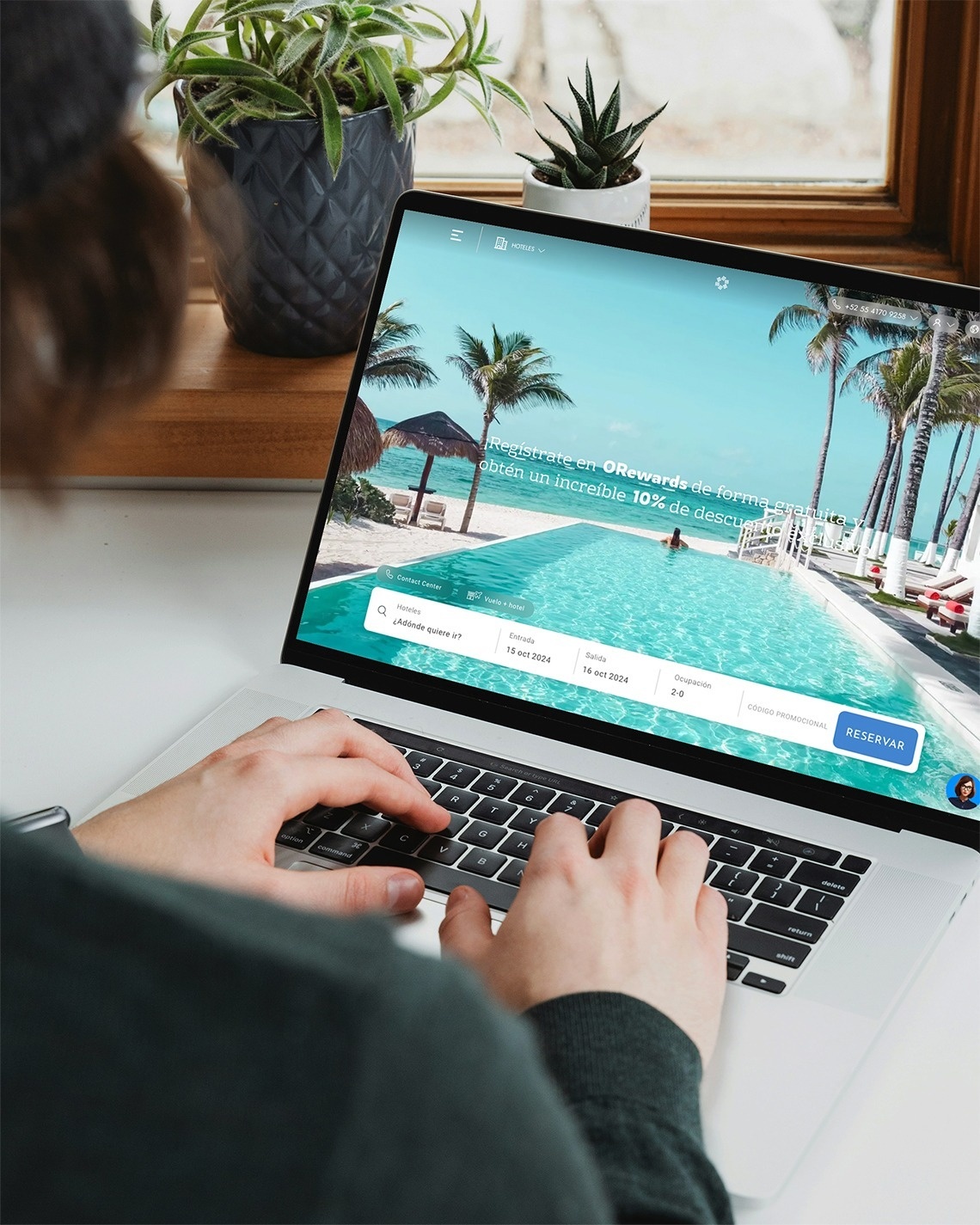 una mujer sonríe mientras usa una computadora portátil con la página web oficial en la pantalla