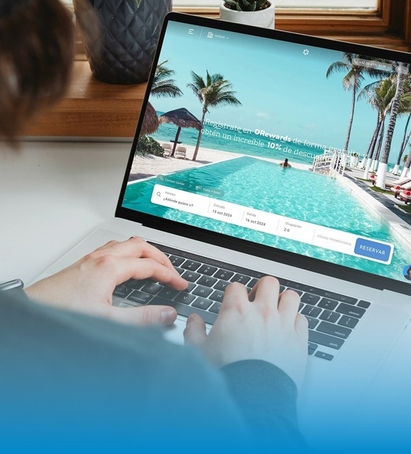 una mujer sonríe mientras usa una computadora portátil con la página web oficial en la pantalla