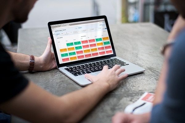 um homem está usando um laptop com um dashboard na tela