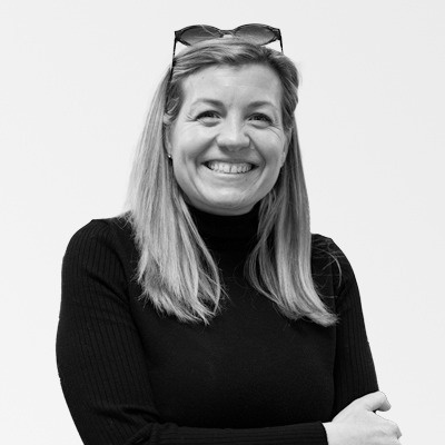 a woman wearing sunglasses smiles in a black and white photo