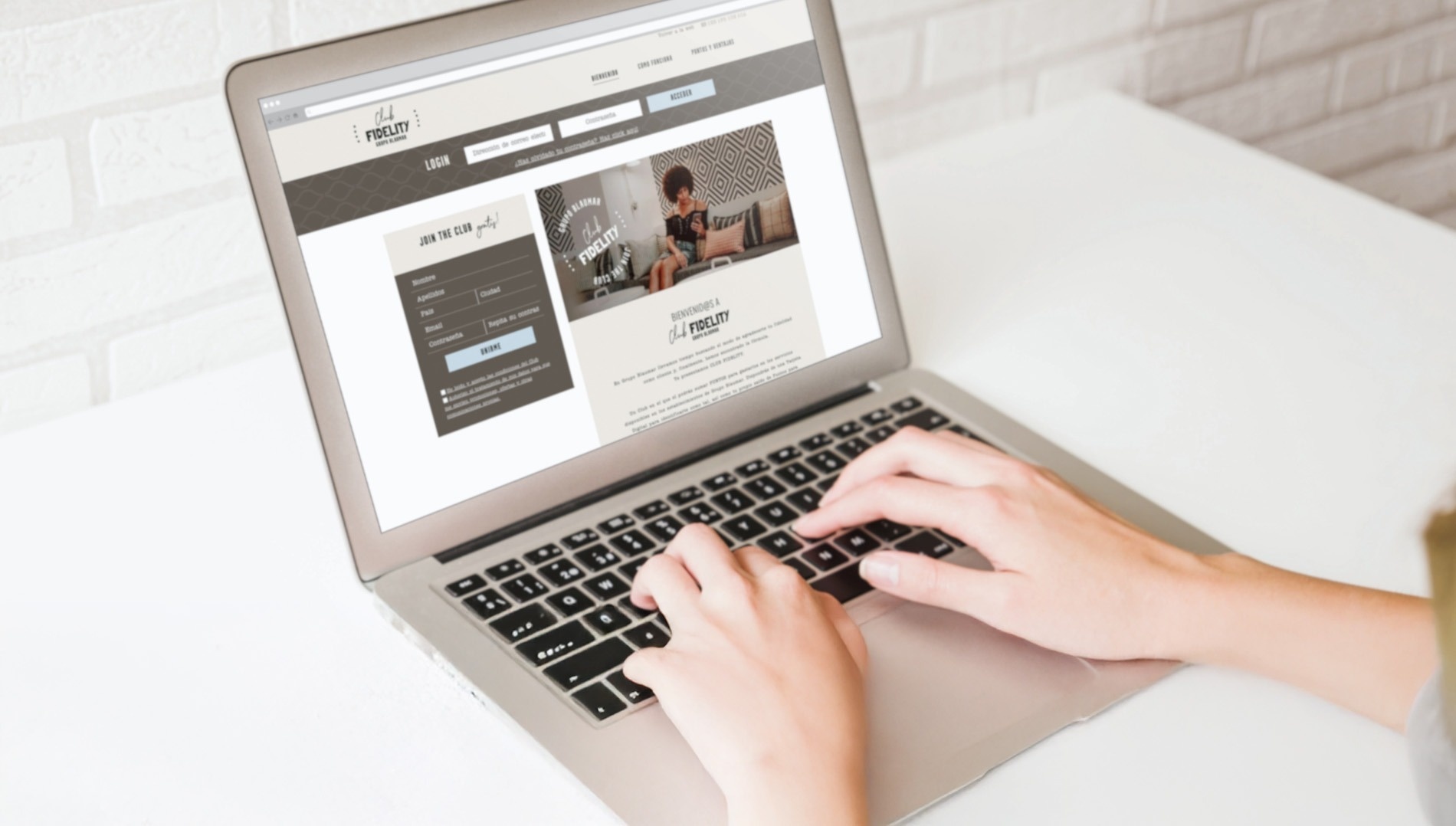 uma pessoa está digitando em um laptop com a página de login em exibição