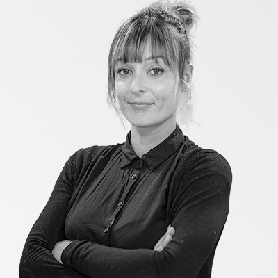 a black and white photo of a woman with her arms crossed .