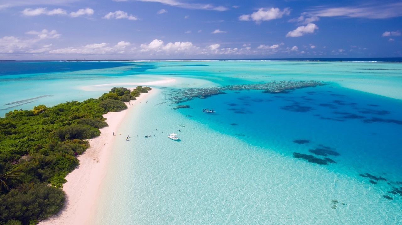 an aerial view of a sandy island in the middle of the ocean