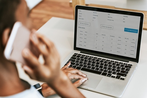 dos hombres miran una computadora portátil que muestra una pantalla de dashboard