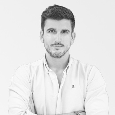 a man wearing a white shirt with a skull and crossbones embroidered on it