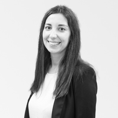 a black and white photo of a woman wearing a white shirt and a black jacket