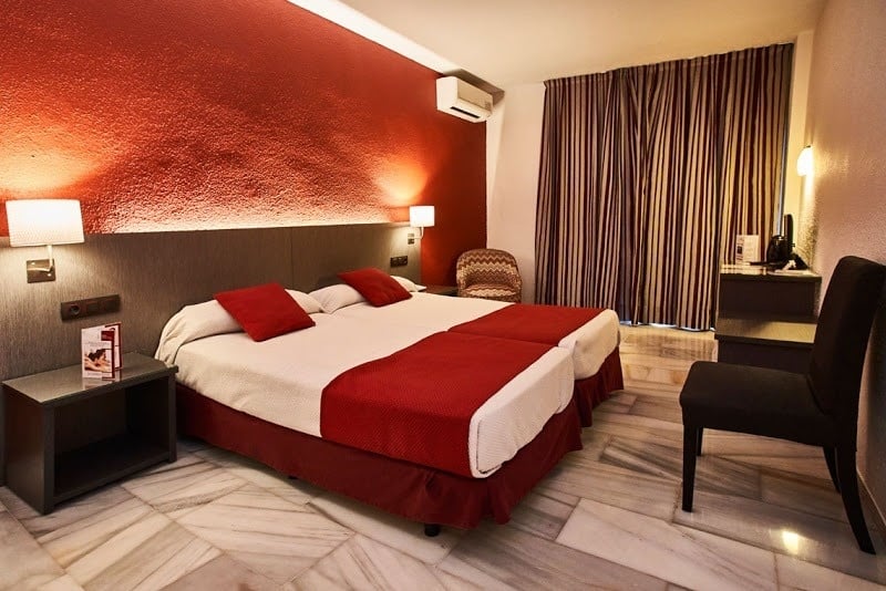una habitación de hotel con dos camas y una silla