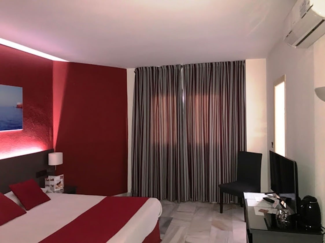 una habitación de hotel con una cama y una televisión
