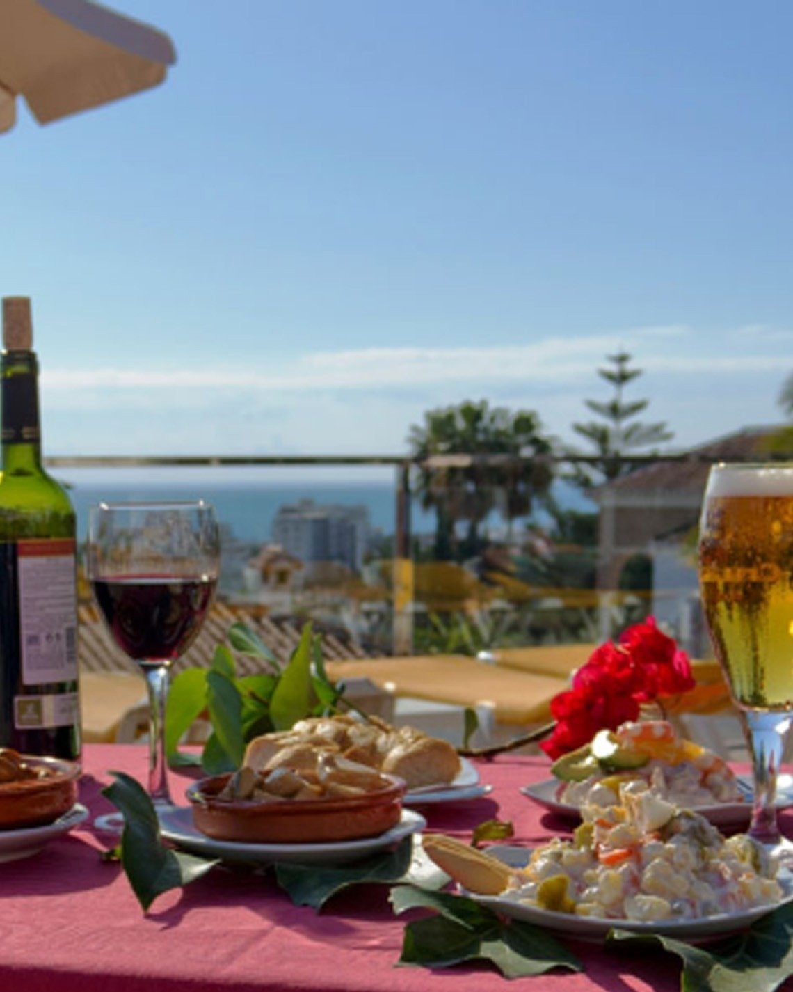 una mesa con platos de comida y una botella de vino
