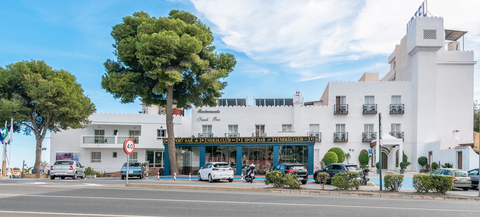 un edificio blanco con un restaurante y un bar en la parte delantera