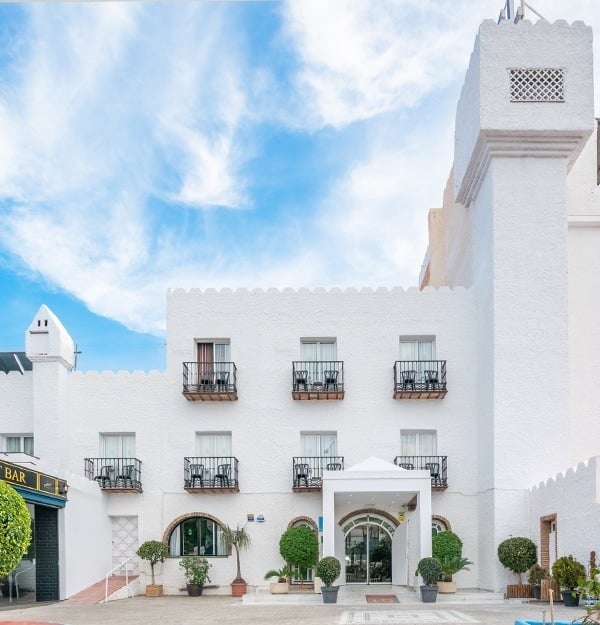un edificio blanco con balcones y una torre en la parte superior