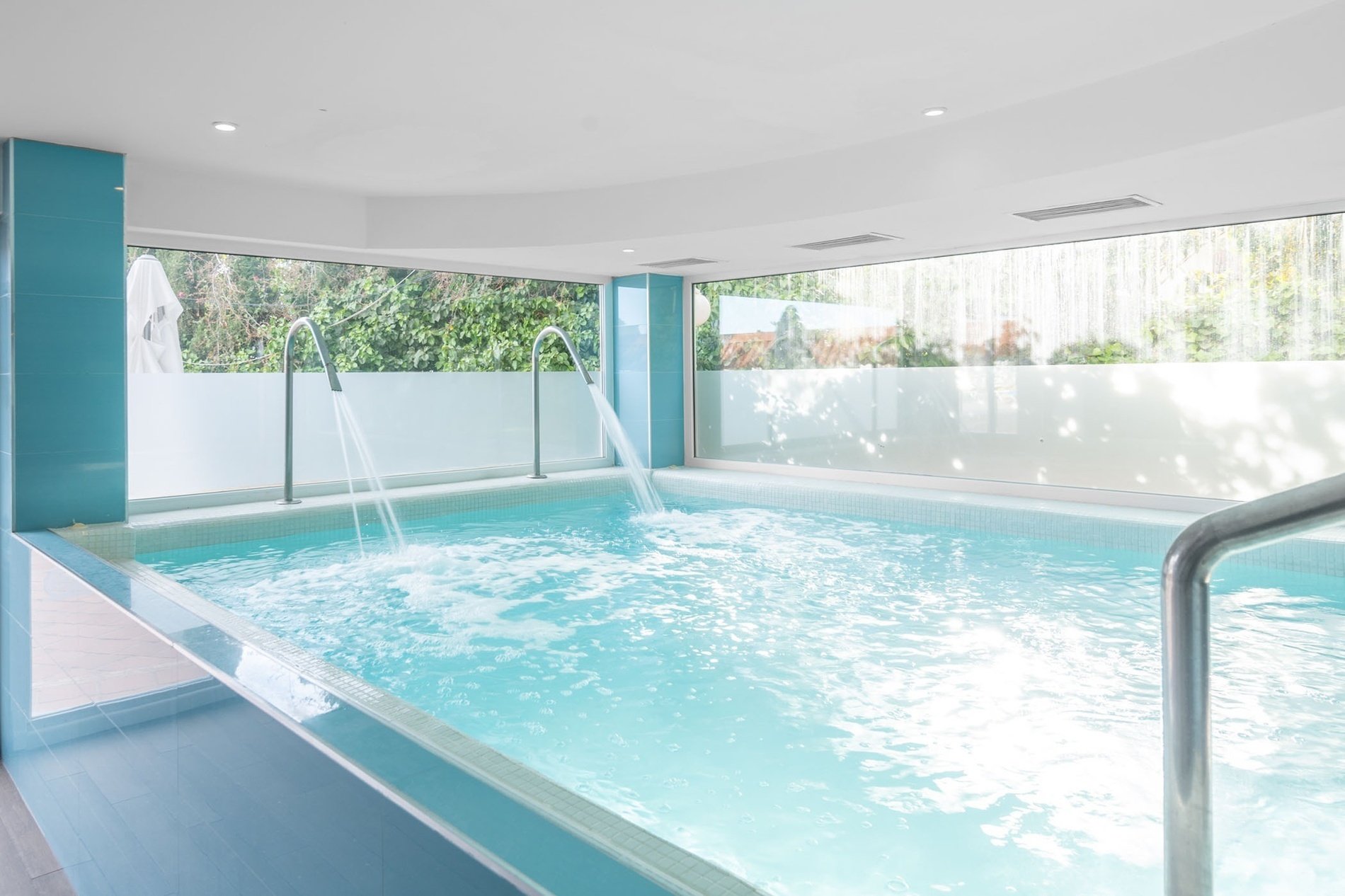una piscina con agua azul y azulejos blancos