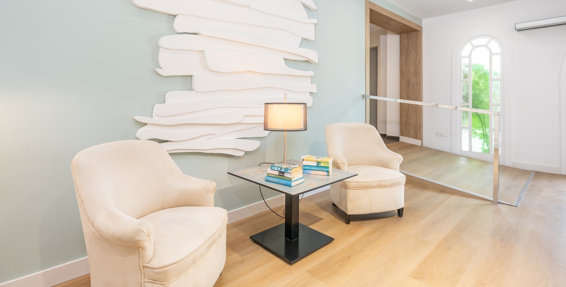 a stack of books sits on a table next to two chairs