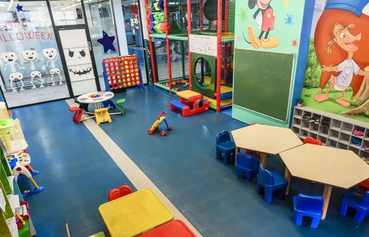 Zona infantil en ESTIVAL: Park Silmar con mesas, sillas y juegos para niños.