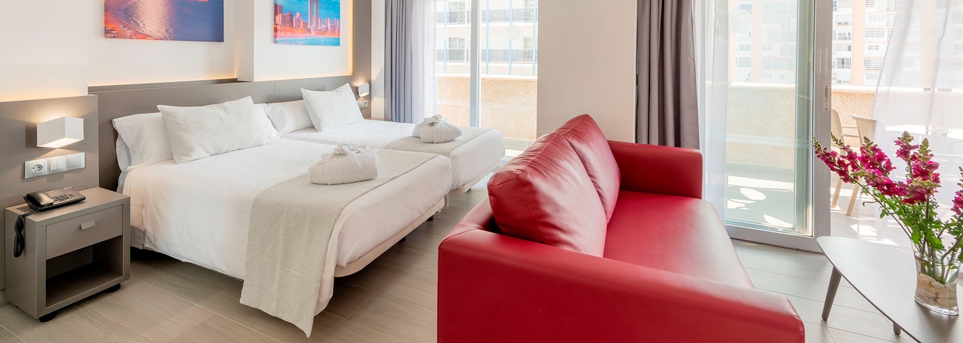 een hotelkamer met twee bedden en een rode bank