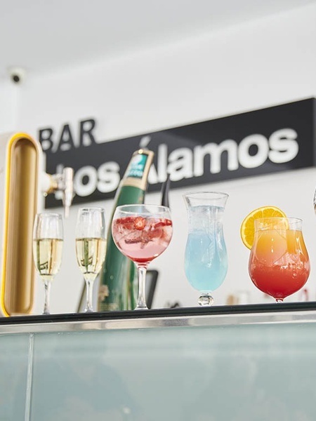 varios cócteles están sobre un mostrador en un bar