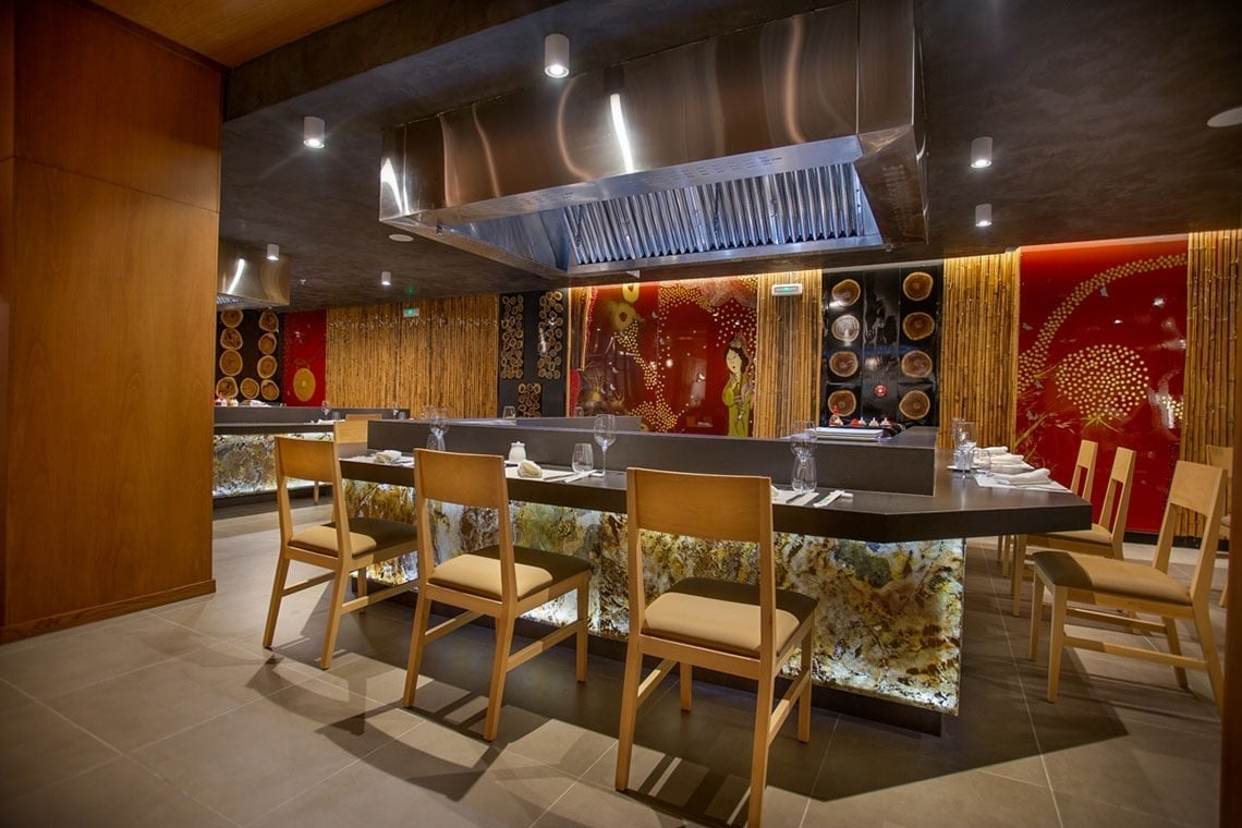 a restaurant with a stainless steel hood over the counter