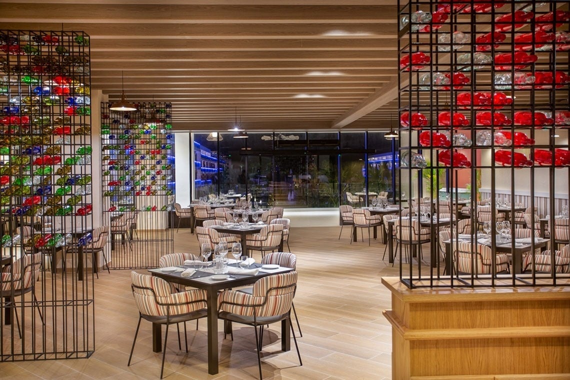 a restaurant with tables and chairs and a glass wall
