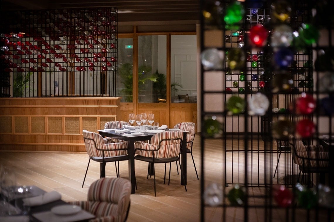 a restaurant with tables and chairs and bottles of wine