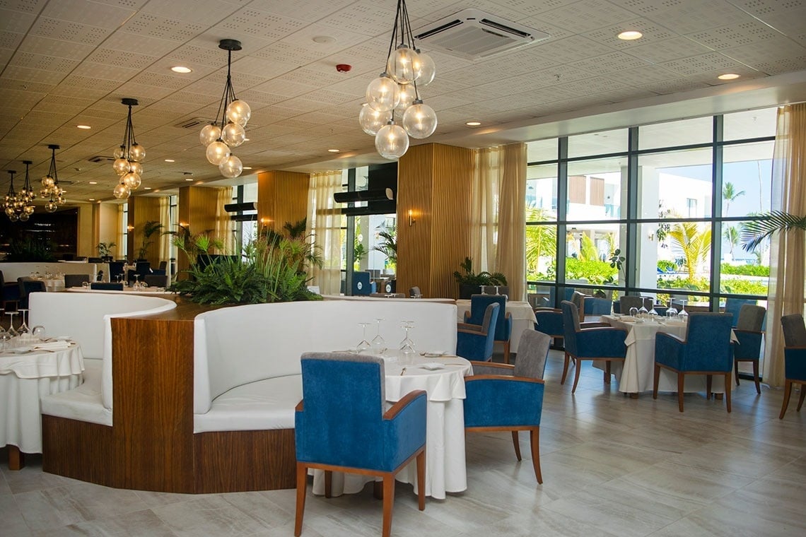 a restaurant with blue chairs and white tables