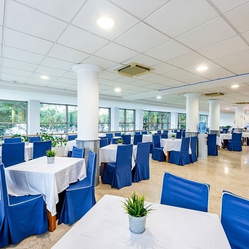 a dining room with blue chairs and white tables