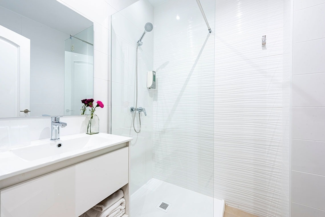 a bathroom with a walk in shower and a sink