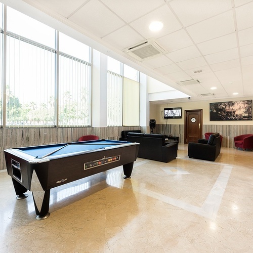 a pool table in a living room with a tv on the wall