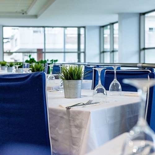 a restaurant with blue chairs and white tables