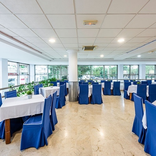 a dining room with blue chairs and white tables