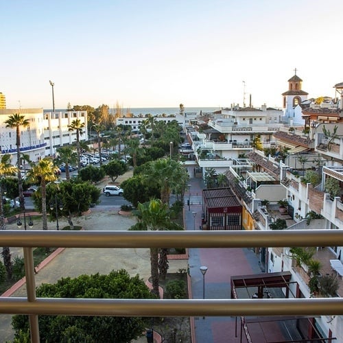 una vista de una ciudad desde un balcón con edificios y palmeras