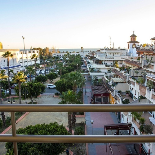 una vista de una ciudad desde un balcón con edificios y palmeras