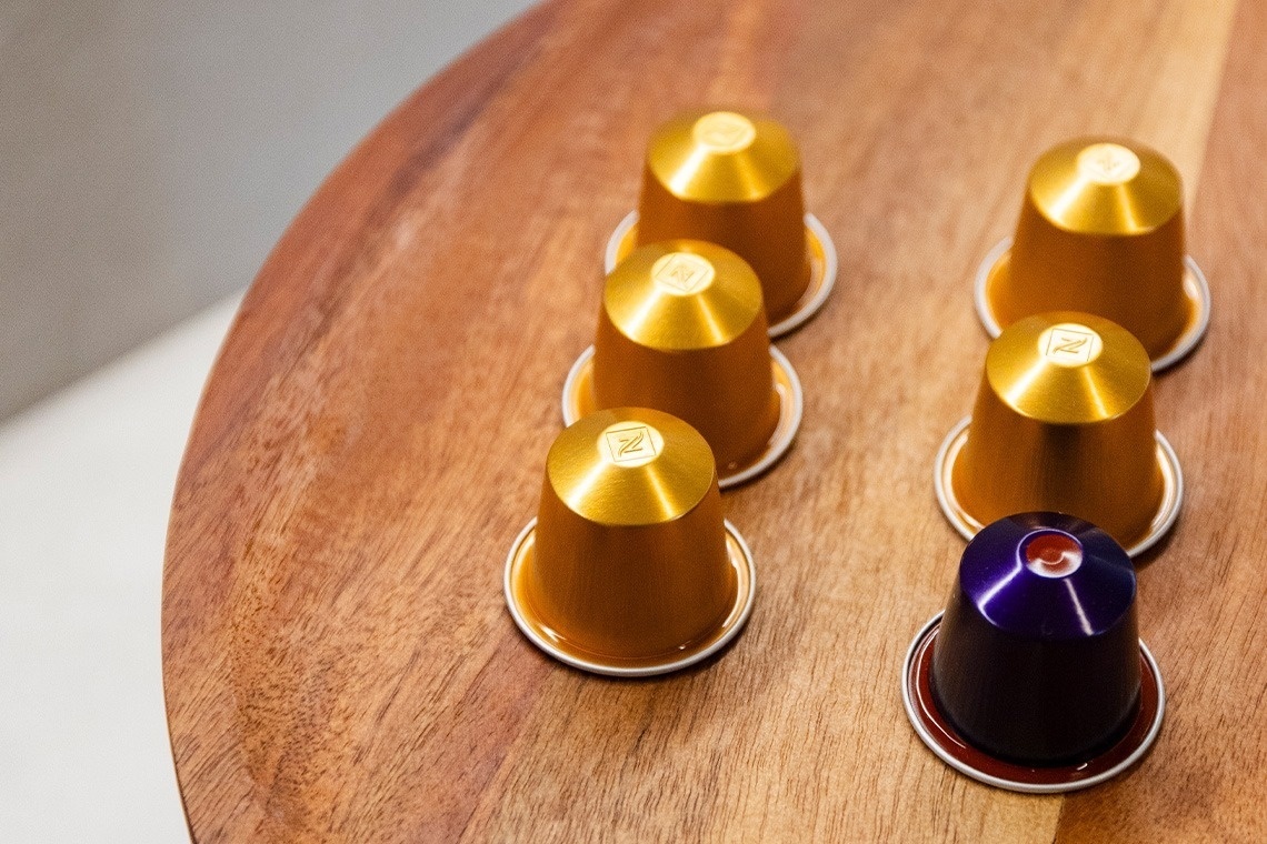 nespresso capsules are lined up on a wooden table