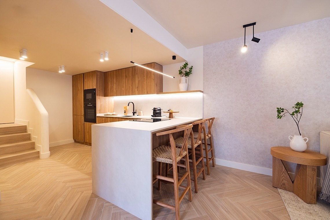 a kitchen with a white counter top and wooden cabinets